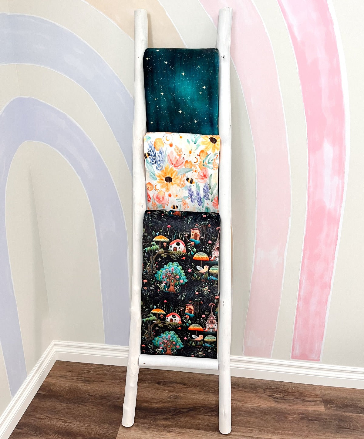 Blanket ladder displaying our 3 prints: Starlight, Bumble, and Pixie. 